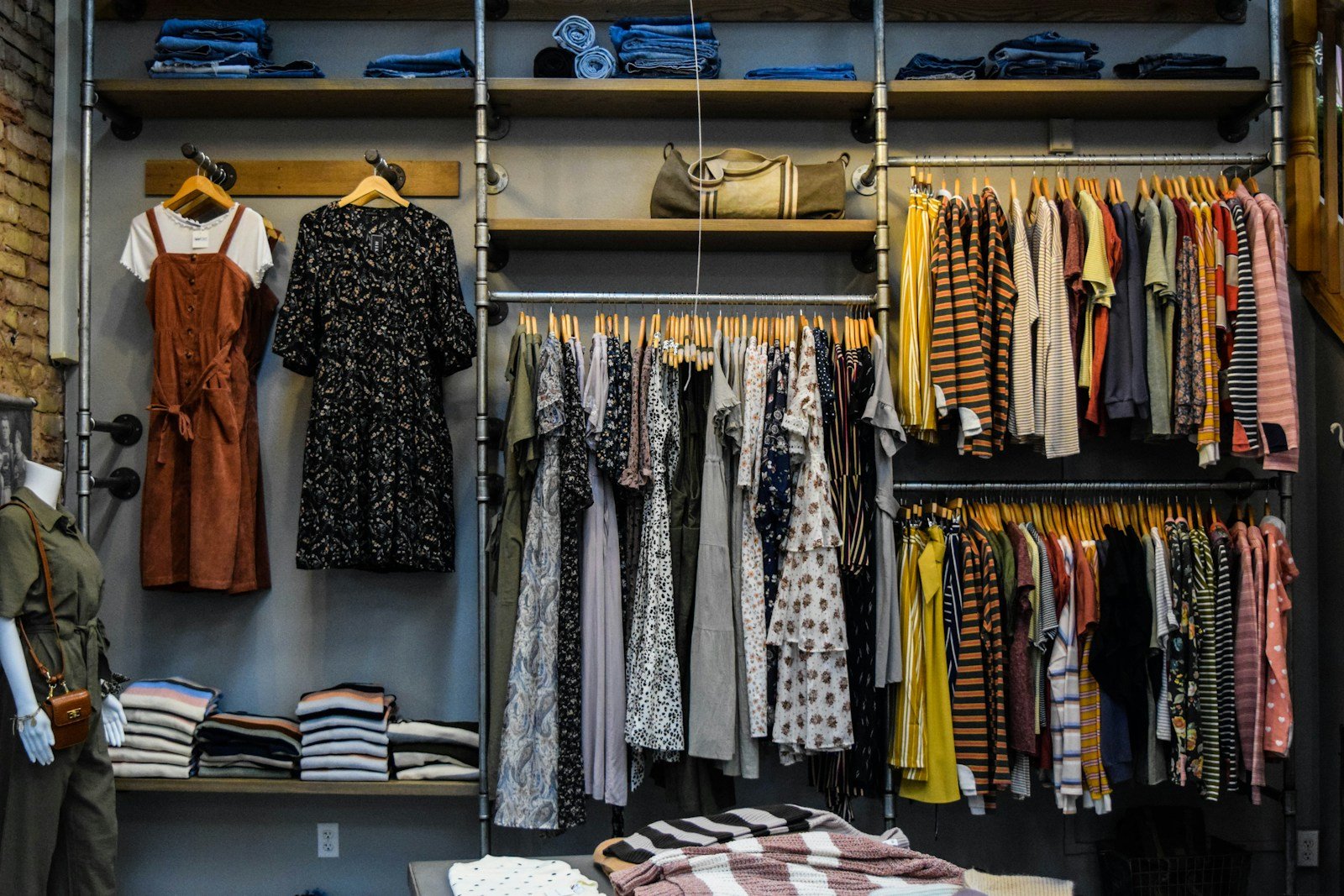 Araras e prateleiras com roupas organizadas na loja